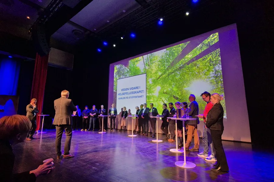 mennesker samlet i en halvsirkel på en scene